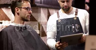 男理发师向顾客展示数码平板电脑